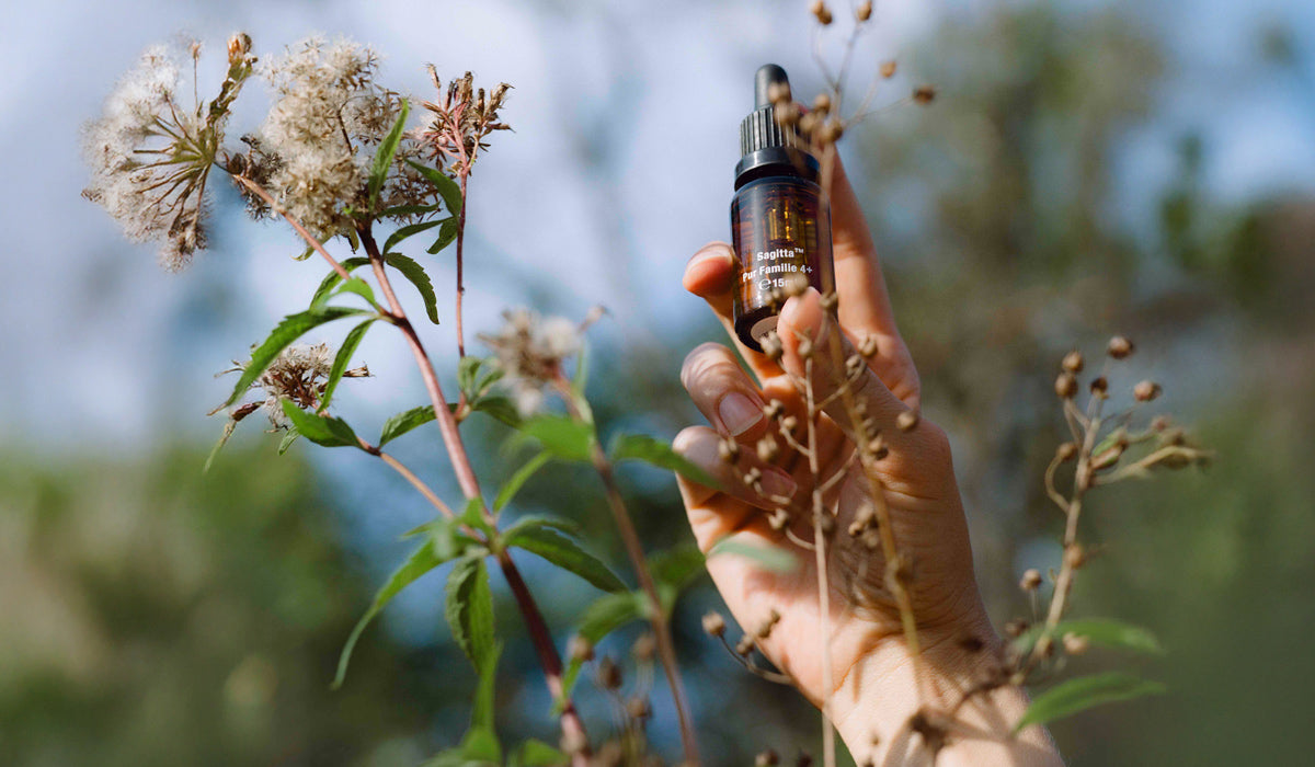 Sagitta Pur Familie Probiotikum in einer Hand vor Blumen